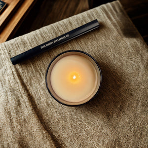 Top view of a lit Archive collection candle with a rechargeable electric candle lighter by Five Thirty PM Candle Co®.