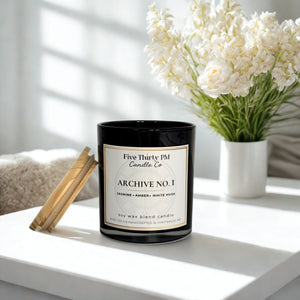 Archive No. 1 candle by Five Thirty PM Candle Co® in a black glass jar with bamboo lid, featuring jasmine, amber, and white musk fragrance notes.