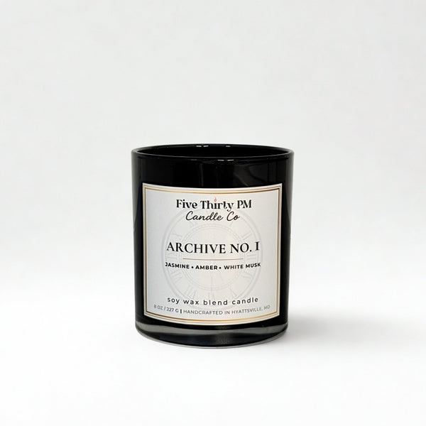 Archive No. 1 First Light candle by Five Thirty PM Candle Co® in a black glass jar with jasmine, amber, and white musk fragrance notes.