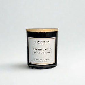 Archive No. 2 Becoming candle by Five Thirty PM Candle Co® in a black glass jar with oud, sandalwood, and musk fragrance notes.