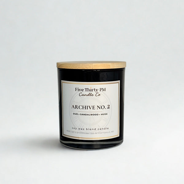 Archive No. 2 Becoming candle by Five Thirty PM Candle Co® in a black glass jar with oud, sandalwood, and musk fragrance notes.