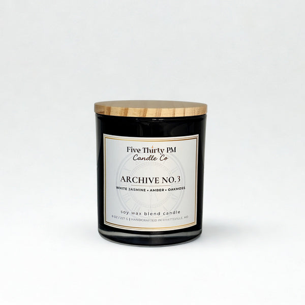 Archive No. 3 Becoming Still candle by Five Thirty PM Candle Co® in a black glass jar with white jasmine, amber, and oakmoss fragrance notes.