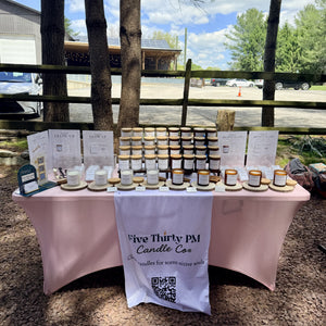 A table display featuring Five Thirty PM Candle Co® Glow Up and Archive of Life candles and wax melts.