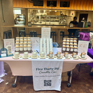 A table display featuring Five Thirty PM Candle Co® Glow Up and Archive of Life candles and wax melts.