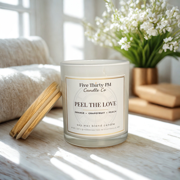 Peel the Love candle by Five Thirty PM Candle Co® in a white glass jar with wooden lid in a bright home setting, featuring orange, grapefruit, and peach fragrance notes.