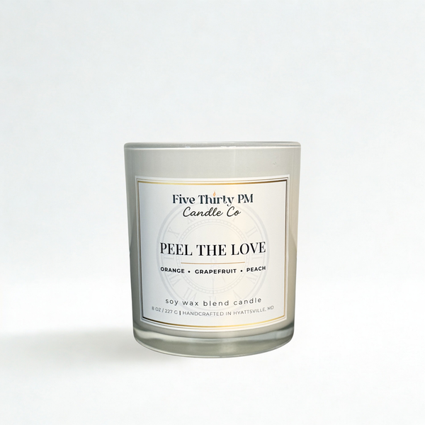 Open Peel the Love candle by Five Thirty PM Candle Co® in a white glass jar, featuring orange, grapefruit, and peach fragrance notes.