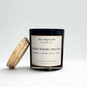 Right Where I Belong candle by Five Thirty PM Candle Co® in a black glass jar with a wooden lid and bergamot, lavender, vanilla, and amber fragrance notes.
