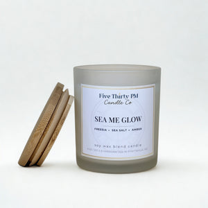 Sea Me Glow candle by Five Thirty PM Candle Co® in a white glass jar with a bamboo lid and orchid and sea salt fragrance notes.