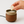 Hand placing a wax melt cube into an electric wax warmer for a flameless home fragrance experience.